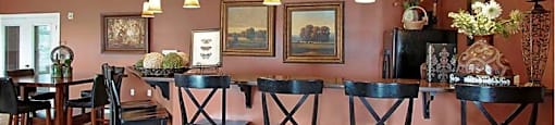 A dining room with a table and chairs.