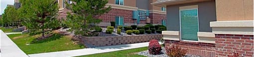 A large apartment complex with a well-maintained lawn and landscaping.