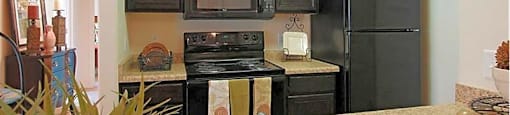 A kitchen with a stove, microwave, and refrigerator.