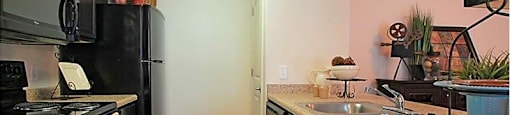 A kitchen with black cabinets and a black refrigerator.