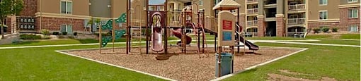 A playground area in front of apartment buildings.
