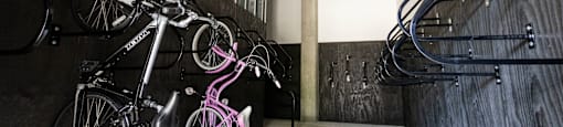 a row of bikes hanging on a wall next to a staircase at Analog PDX Apartments, Portland, OR