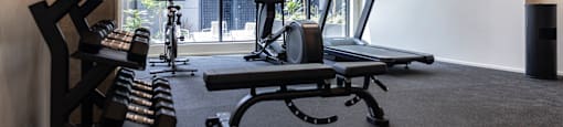 a gym with treadmills and other exercise equipment in front of a window at Analog PDX Apartments, Oregon 97227