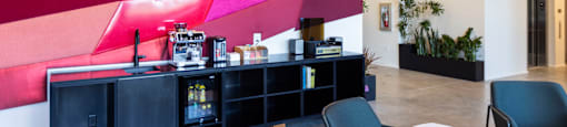 a lobby with a counter and chairs and a colorful wall at Analog PDX Apartments, Portland, OR