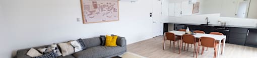 a living room and dining room with a couch and a table at Analog PDX Apartments, Portland, OR