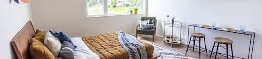 a bedroom with a bed and a desk and a window at Analog PDX Apartments, Portland, OR