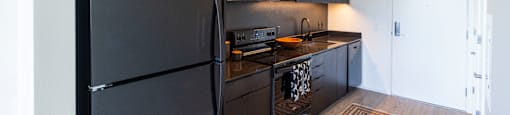 a kitchen with black appliances and a black refrigerator at Analog PDX Apartments, Portland