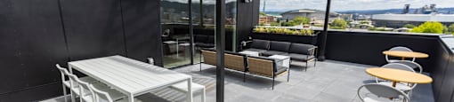 a rooftop patio with a table and chairs and a canopy at Analog PDX Apartments, Portland, OR 97227