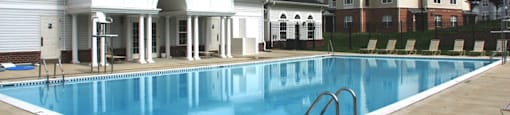 A large swimming pool in front of a building.