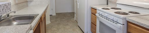 A kitchen with white appliances and wooden cabinets.