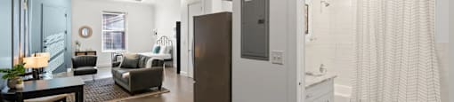 a renovated living room and dining room with a door to the bathroom