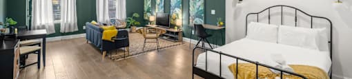 a bedroom with a bed and a living room with a table and chairs