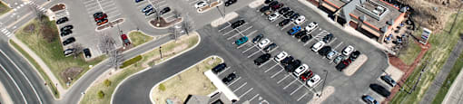 A parking lot with cars and a building in the background.