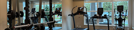 A gym with a mirror, weights and exercise equipment.