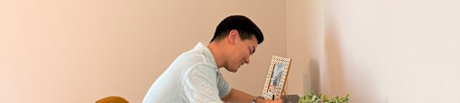 A man is sitting on a chair and holding a plant.