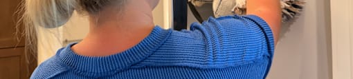 A woman in a blue top is doing laundry.