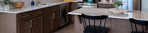 A modern kitchen with wooden cabinets and a white countertop.
