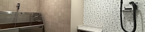 A bathroom with a shower, bench, and tiled walls.