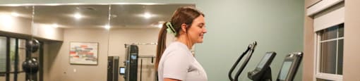 A woman is working out on a treadmill in a gym.