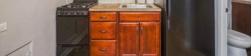 Rich wood cabinetry and tiled backsplash in the kitchen at 1355 Pearl in Denver, CO