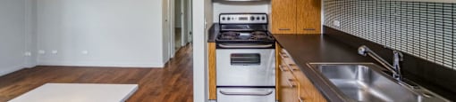Kitchen with built-in microwave, dishwasher and lovely tiled backsplash at Metropolis in Denver, CO