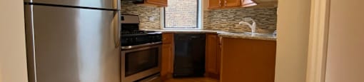 Kitchen with tiled backsplash and stainless steel appliances - 1 Bedroom