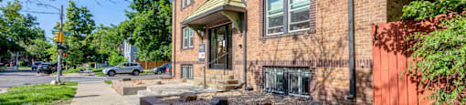 A red brick house with a grey sidewalk in front 1170 N Logan St in Denver, CO