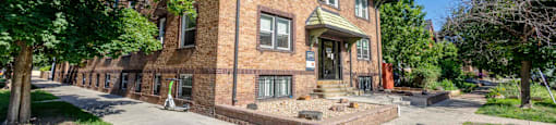 A red brick building with a green roof and a white door 1170 N Logan St in Denver, CO