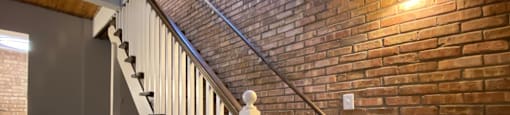 Staircase with exposed brick wall