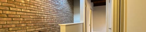 Hallway with exposed brick and staircase