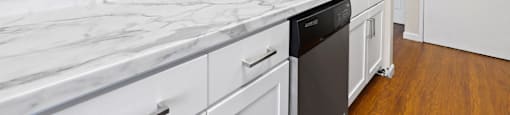 A kitchen with a marble countertop and white cabinets  at 4805 E Kentucky in Denver, CO