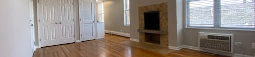 Living room with a ceiling fan and a fireplace - One Bedroom