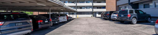 A parking lot with cars and a building in the background at 878 S Dexter St in Denver, CO