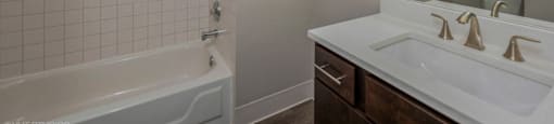 Bathroom with vanity storage and a full tub at Carriage House Lofts, Illinois