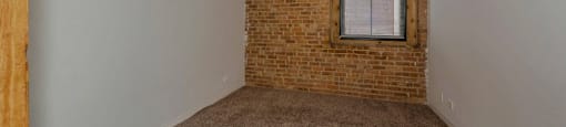Bedroom with exposed brick wall at Carriage House Lofts, Chicago, IL, 60605