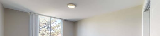 A room with a carpeted floor and a window at 4600 E Kentucky Ave in Denver, CO