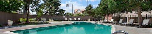 A swimming pool surrounded by trees and chairs at 4600 E Kentucky Ave in Denver, CO