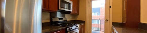 Large kitchen featuring granite countertops, dishwasher, microwave and stainless steel appliances