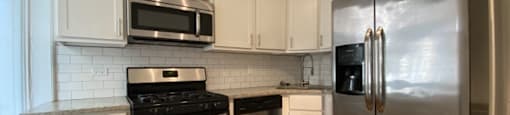 Spacious kitchen space with hardwood floors and stainless steel appliances