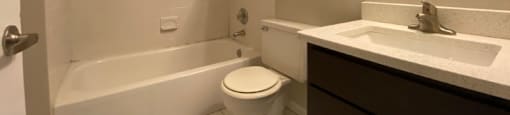 Bathroom with vanity storage and a full tub