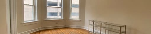 Spacious living space with genuine hardwood floors and large windows