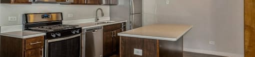Kitchen with rich wood cabinetry and stainless steel appliances at Carriage House Lofts, Chicago, 60605
