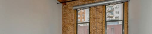 Room with a ceiling fan and two large windows at Carriage House Lofts, Chicago