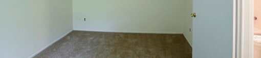 an empty room with white walls and a carpet