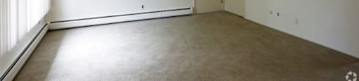 an empty living room with white walls and a door
