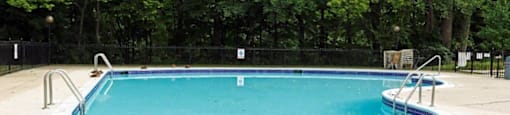 a swimming pool with trees in the background