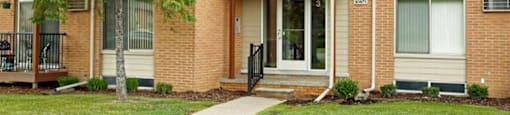 a brick house with a sidewalk in front of it