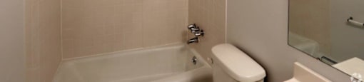 a white bathroom with a tub and a toilet and a sink