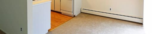 an empty kitchen with a ceiling fan and white appliances