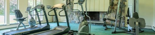 a home gym with exercise equipment and a fireplace
